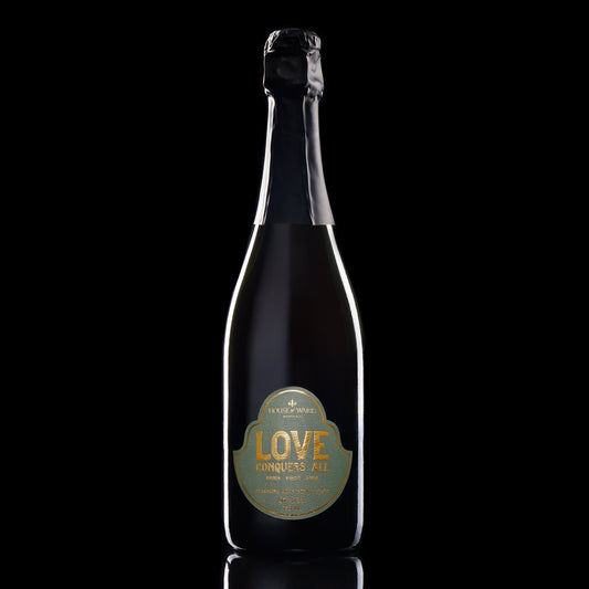 Bottle of 'LOVE' champagne with a gold label on a black background